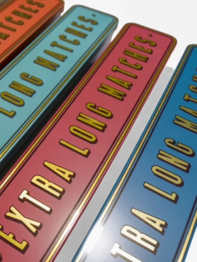 Beautiful steel tins in a range of rich colours with the words Extra Long Matches in gold font.