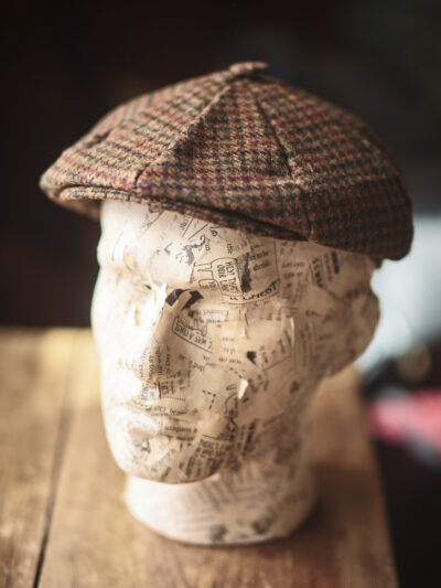 A model head wearing a traditional flat cap